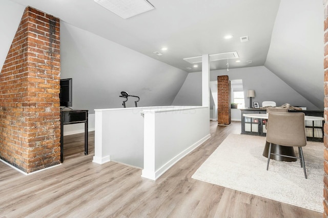 home office featuring vaulted ceiling and light hardwood / wood-style flooring