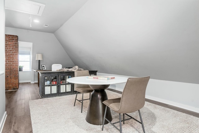 dining room with dark wood-type flooring and lofted ceiling