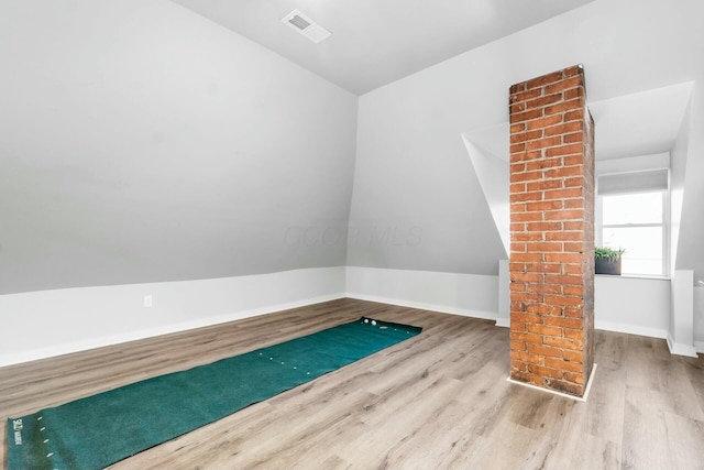 interior space with light wood-type flooring and vaulted ceiling