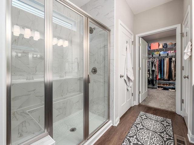 bathroom featuring wood-type flooring and a shower with shower door