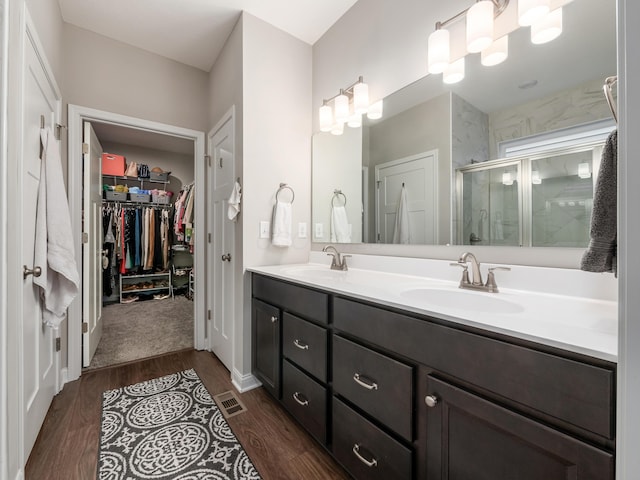 bathroom with vanity, an enclosed shower, and hardwood / wood-style flooring