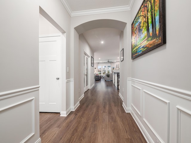 corridor with dark hardwood / wood-style flooring and ornamental molding