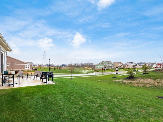 view of property's community featuring a lawn and a patio