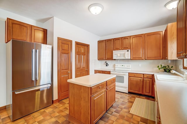 kitchen featuring a center island, white appliances, sink, and tasteful backsplash