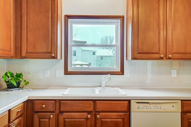 kitchen with dishwasher, decorative backsplash, and sink