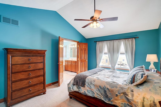 bedroom with ceiling fan, lofted ceiling, light carpet, and connected bathroom