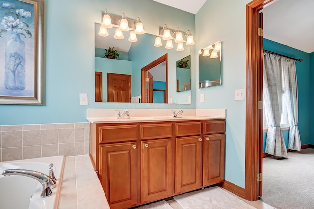 bathroom with vanity and a relaxing tiled tub