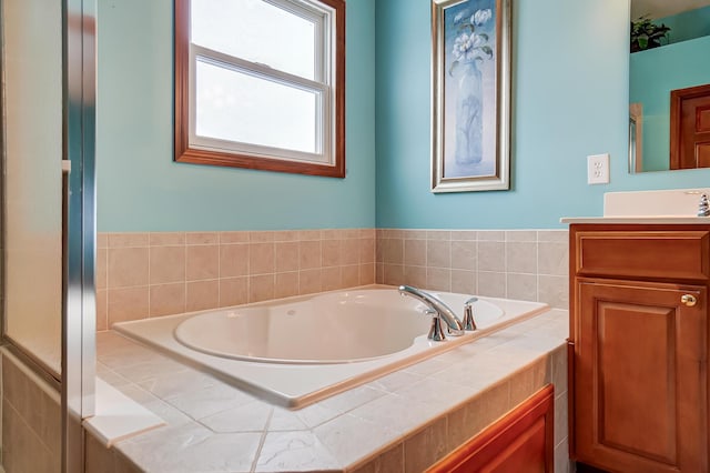 bathroom featuring vanity and tiled bath