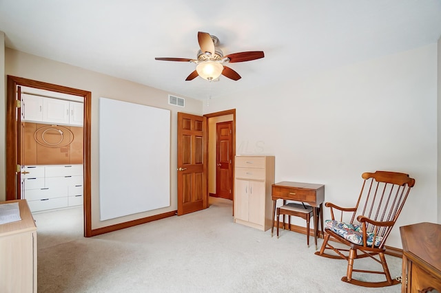 living area with ceiling fan and light colored carpet