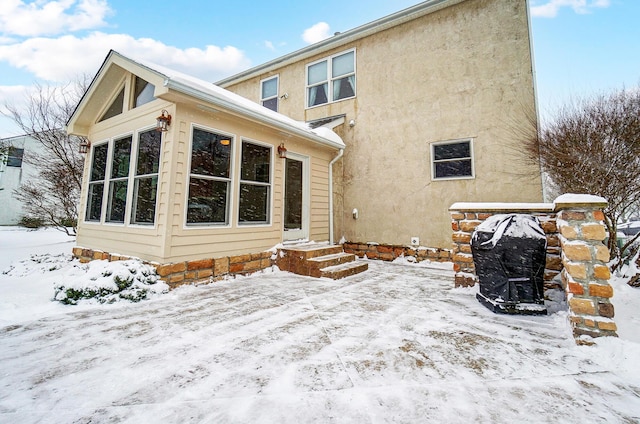 view of snow covered rear of property