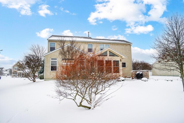 view of snow covered back of property