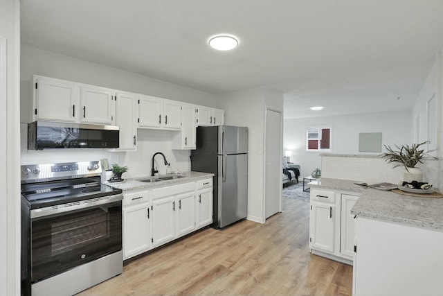 kitchen featuring sink, white cabinetry, stainless steel appliances, and light hardwood / wood-style flooring