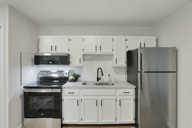 kitchen featuring white cabinets, backsplash, sink, and appliances with stainless steel finishes