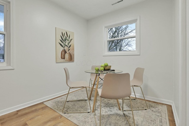 dining space with wood-type flooring