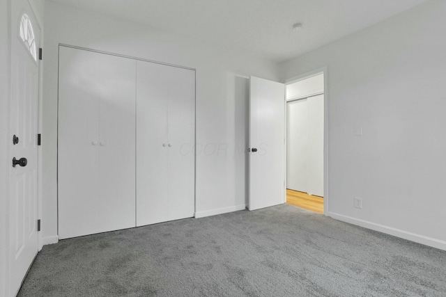 unfurnished bedroom featuring carpet flooring and a closet