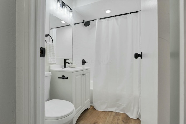 bathroom with a shower with curtain, hardwood / wood-style floors, vanity, and toilet