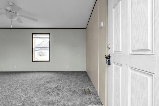 empty room featuring carpet floors, ceiling fan, and crown molding