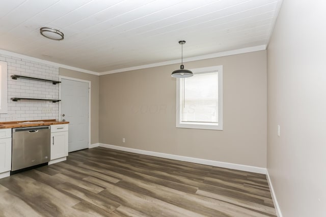 kitchen with butcher block counters, white cabinetry, stainless steel dishwasher, decorative light fixtures, and ornamental molding