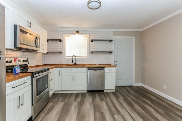 kitchen featuring butcher block countertops, sink, white cabinets, and appliances with stainless steel finishes