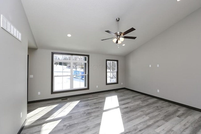 spare room with ceiling fan, lofted ceiling, and light hardwood / wood-style flooring