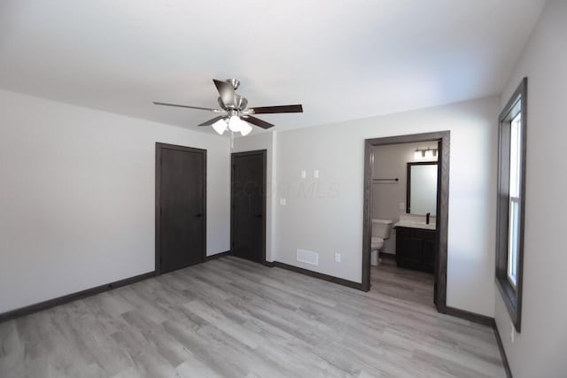 unfurnished bedroom with ceiling fan, a closet, ensuite bathroom, and light hardwood / wood-style flooring