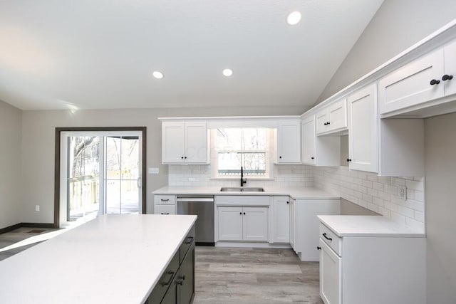 kitchen with stainless steel dishwasher, white cabinetry, and sink