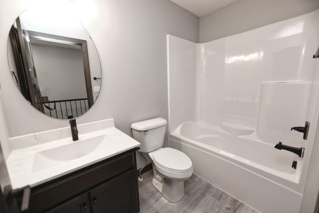 full bathroom with hardwood / wood-style floors, vanity, bathtub / shower combination, and toilet