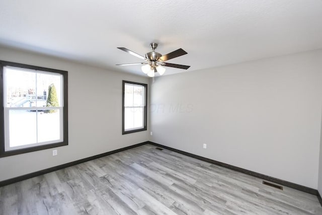 empty room with ceiling fan and light wood-type flooring