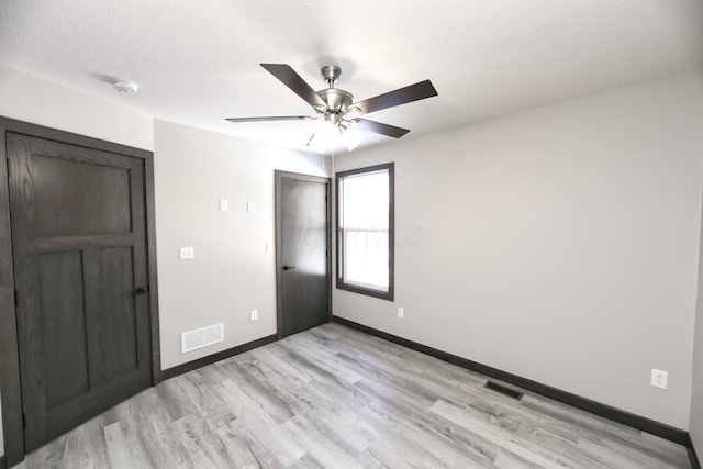 interior space featuring ceiling fan, light hardwood / wood-style floors, and a textured ceiling