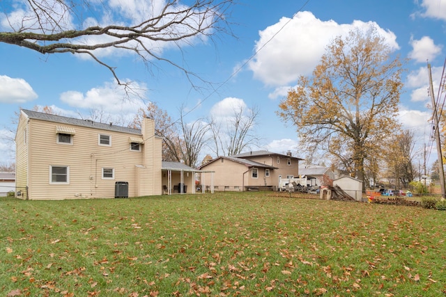 back of property featuring a lawn and central air condition unit