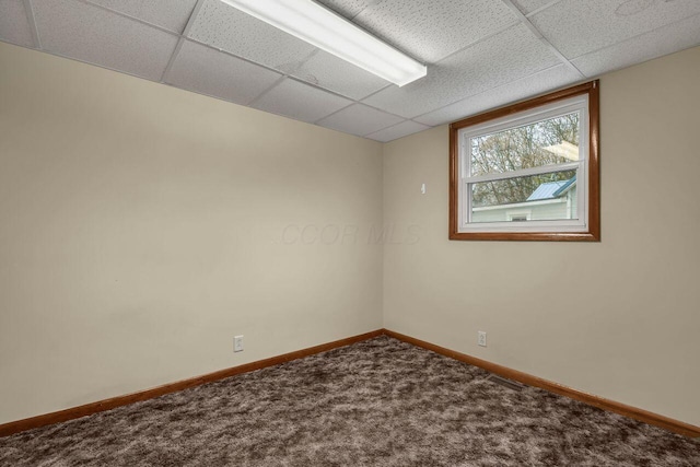 carpeted empty room featuring a paneled ceiling