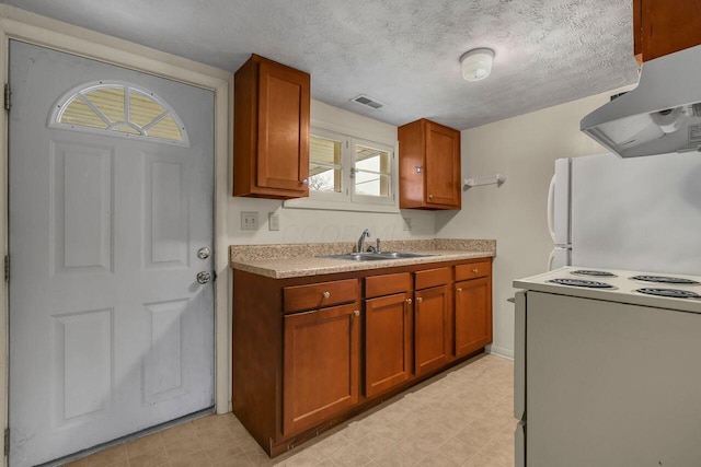 kitchen with stove, a textured ceiling, sink, exhaust hood, and white refrigerator