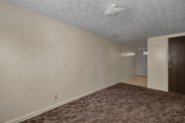 carpeted empty room with a textured ceiling