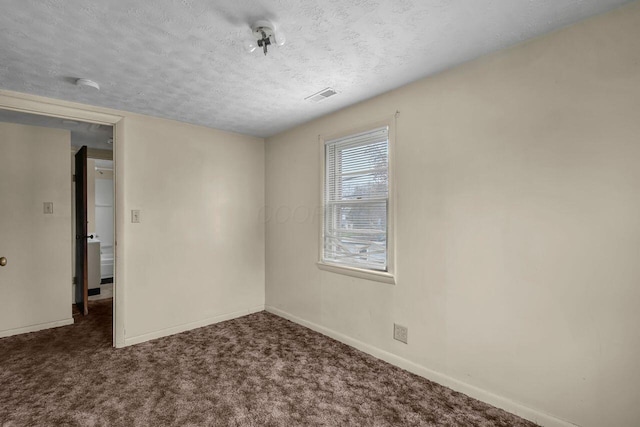 empty room featuring dark colored carpet and a textured ceiling