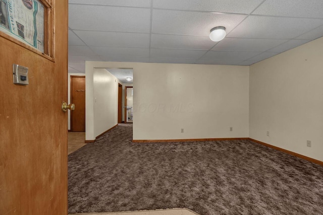 spare room featuring a paneled ceiling and carpet floors