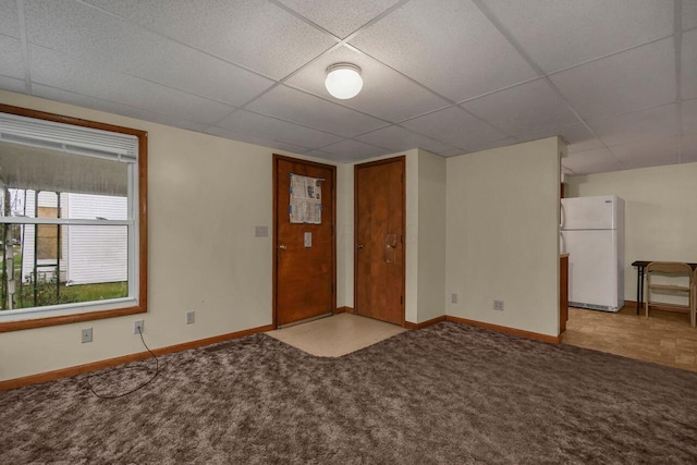 carpeted spare room featuring a paneled ceiling