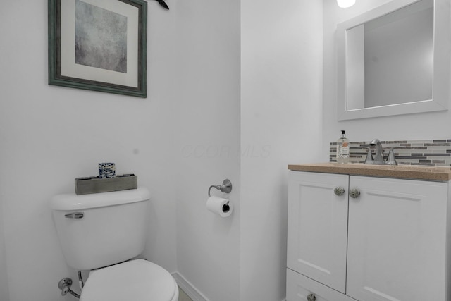 bathroom featuring vanity, tasteful backsplash, and toilet