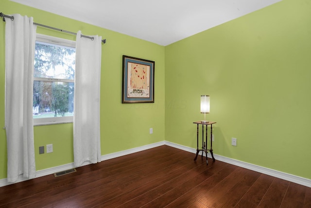 empty room with dark hardwood / wood-style flooring