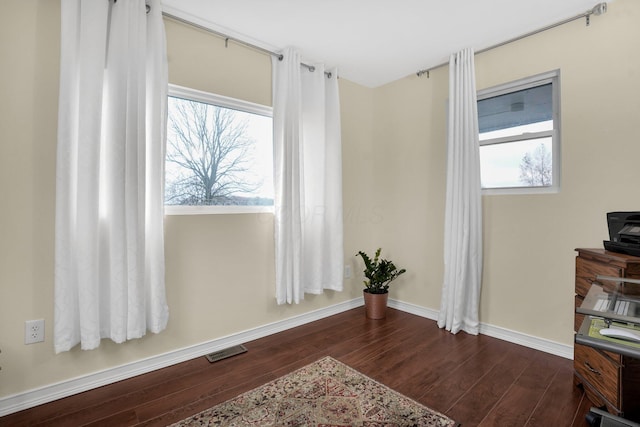 living area with dark hardwood / wood-style flooring and plenty of natural light