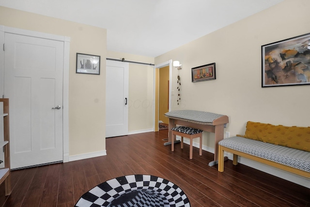 living area with a barn door and dark wood-type flooring