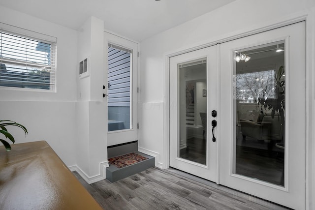 entryway with a notable chandelier and wood-type flooring