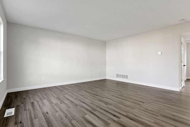 spare room featuring wood-type flooring and a textured ceiling