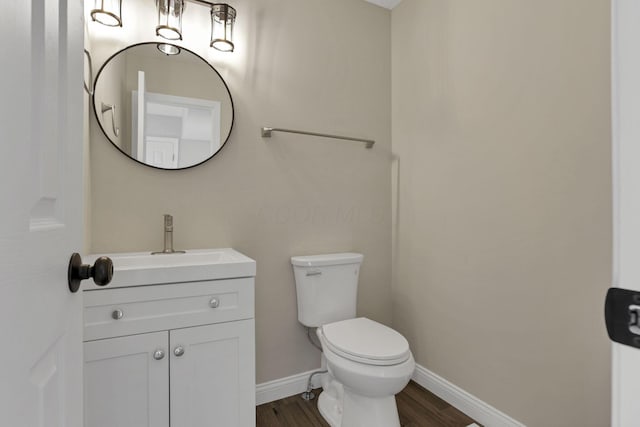 bathroom with toilet, vanity, and hardwood / wood-style flooring