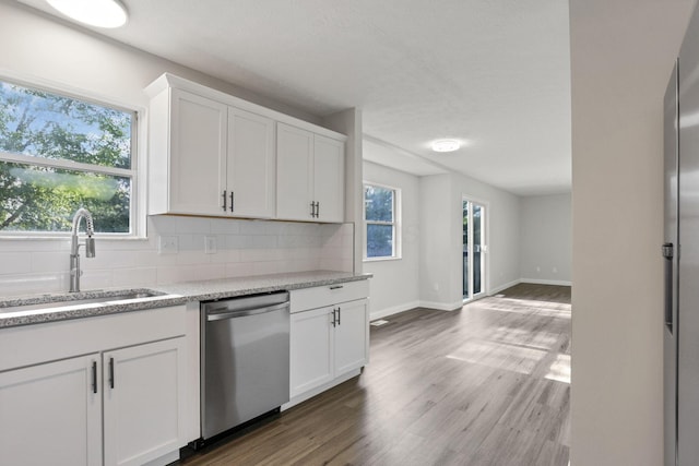 kitchen with dishwasher, white cabinetry, sink, and a wealth of natural light