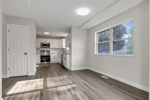 kitchen featuring sink, white cabinets, stainless steel appliances, and light wood-type flooring