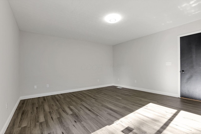 spare room featuring dark hardwood / wood-style flooring