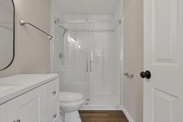 bathroom with hardwood / wood-style floors, vanity, toilet, and an enclosed shower