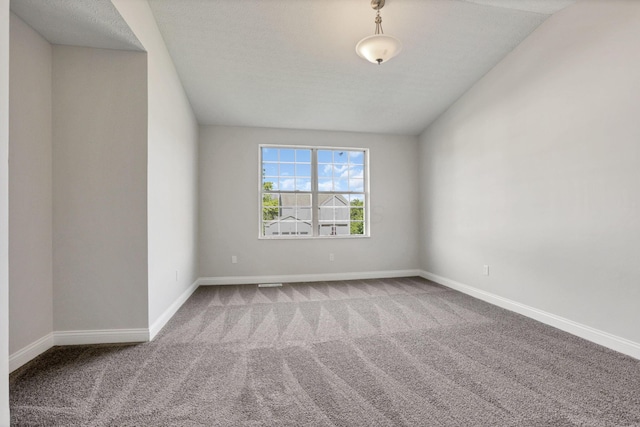 carpeted empty room featuring a textured ceiling