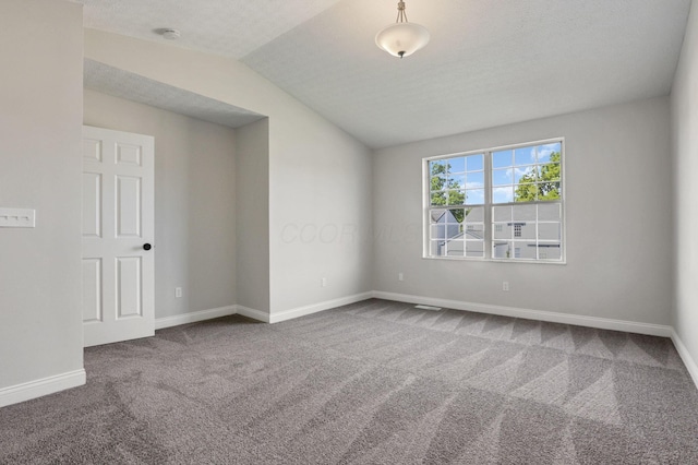 unfurnished room featuring carpet, a textured ceiling, and vaulted ceiling