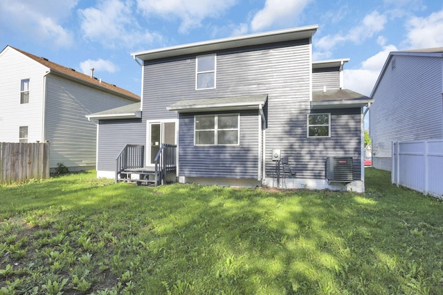 back of property with a lawn and central air condition unit